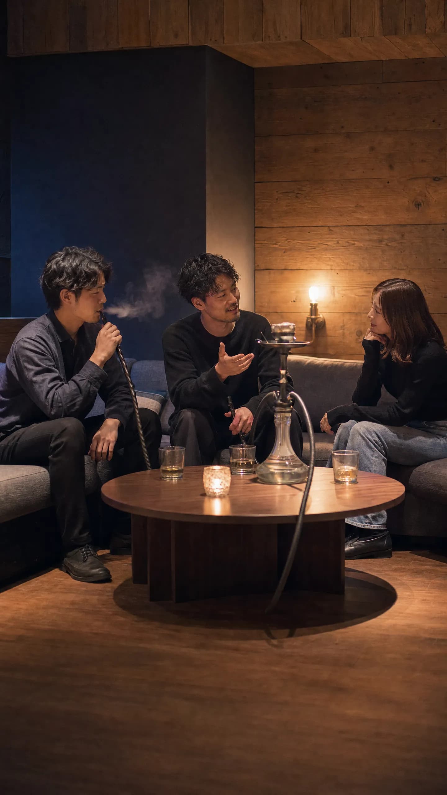 男性2人と女性1人がシーシャを吸いながら自然に会話する様子